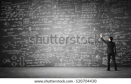 Businessman or teacher drawing science sketches at blackboard