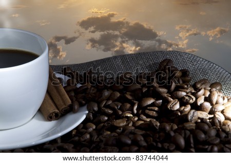 cup of coffee and coffee beans on the Sacking, evening sky background