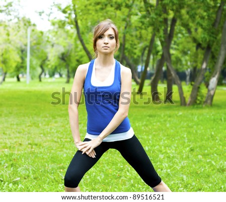 young woman is engaged in yoga, in summer on a green grass