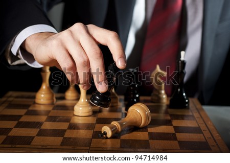image of the businessman in a business suit plays chess