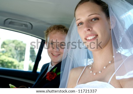 A happy couple recently married - in the back seat of the wedding car