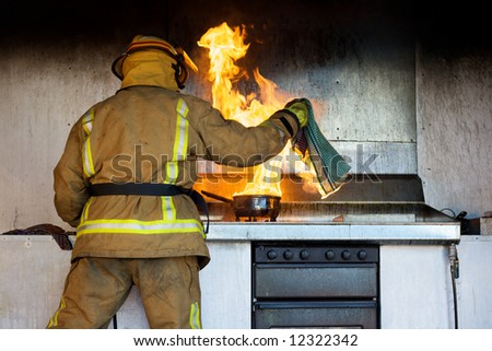 Kitchen fire being put out by a fireman