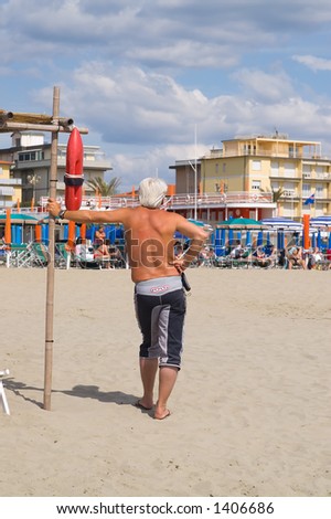 An old man still well-fitted controlling the beach