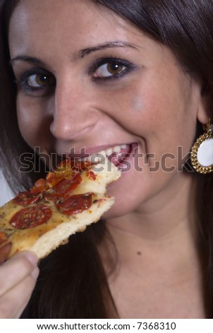 Simple portrait of a nice girl eating a slice of pizza against a clear background