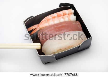 Three pieces of various nigiri in a black box with sticks.  in a black box with sticks.