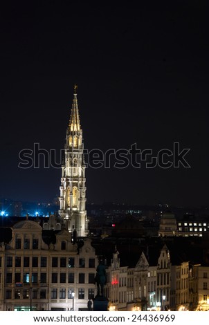 The 96 meter high belfry of Brussels townhall with a five meter high metal statue of archangel Michael patron saint of Brussels faraway photographed at night