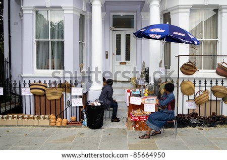 LONDON - AUG 28: old women sell food and other items in  Notting Hill during the traditional  Carnival on August 29, 2011 in London, England.