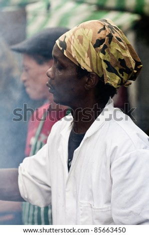 LONDON, ENGLAND - AUGUST 28: Black man cooks chicken wings at a Food\'s stall at the Notting Hill Carnival on August 29, 2011 in London, England.