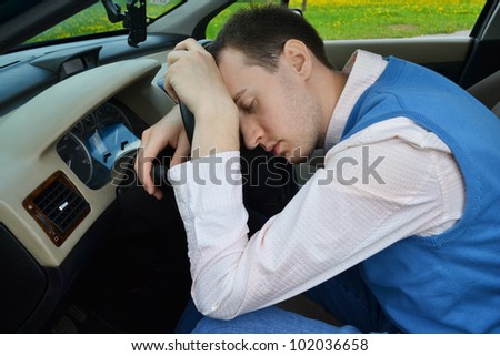 Man sleeps in a car.