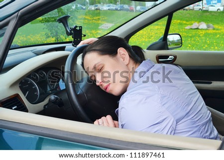 Young girl sleeps in her car.