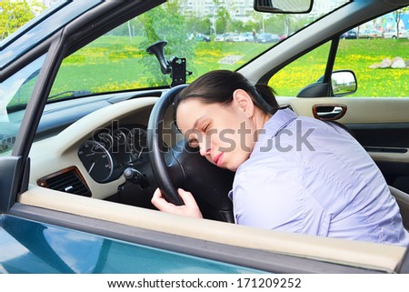 Young girl sleeps in her car.
