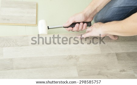 Man with Tools to Laying Laminate