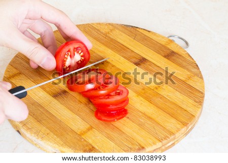 Sliced tomatoes with a knife on a board