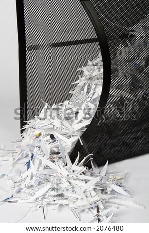 A spilled over paper shredder waste basket