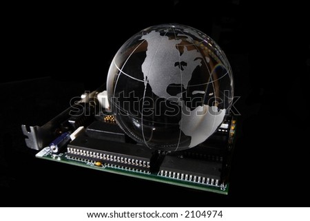 A transparent globe sitting on top of a ethernet network computer card isolated on black