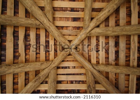 Upward view of a pine timber framed square room with a vaulted ceiling