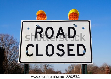 Close up of a road closed sign and warning signals