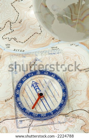 A compass and globe on a topographical map