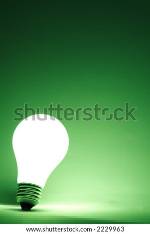 Lit light bulb with a tiled green background