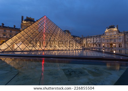 PARIS -JULY 9, 2014 Louvre museum at twilight in summer JULY 9 2014  in Paris, France. Louvre Museum is one of the world\'s largest museums, every year museum visits more than 8 million visitors.