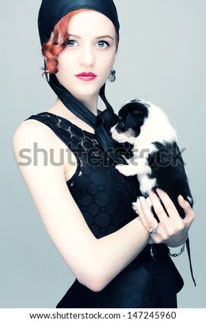 Studio photo red-haired girl in black with a beloved pet.
