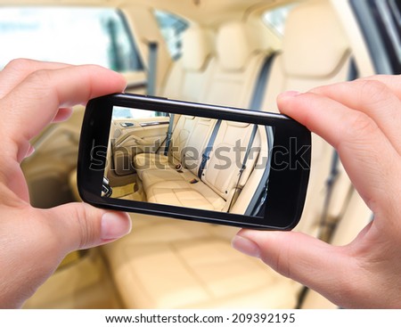 Hands taking photo  car interior with smartphone