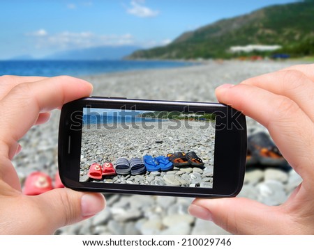 Hands taking photo flip flops with smartphone