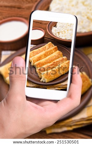 Hands taking photo pancakes with cottage cheese with smartphone.