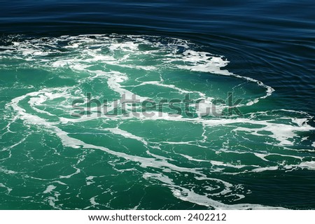 Green water with white foam from boat wake