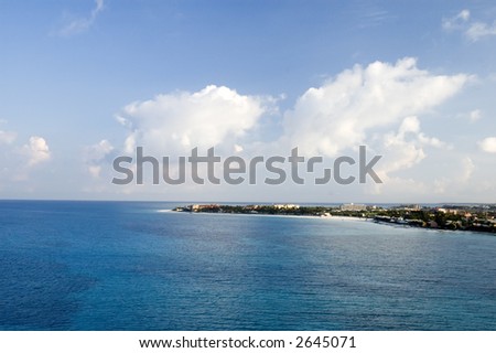 Blue Caribbean ocean water with point of aruba and blue sky and clouds