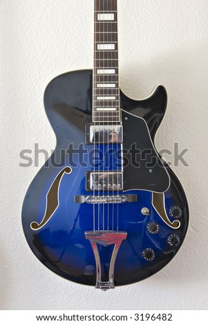 Body detail of blue electric jazz guitar with strings, neck and f-holes