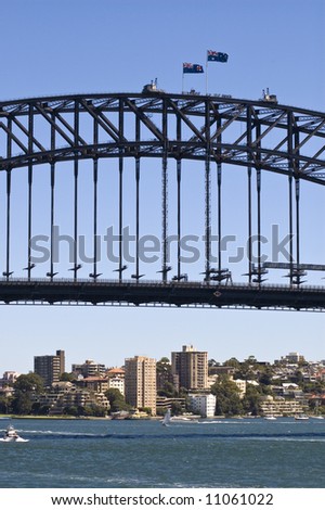 tourists on top on sydney harbor bridge with view of water and buildings below