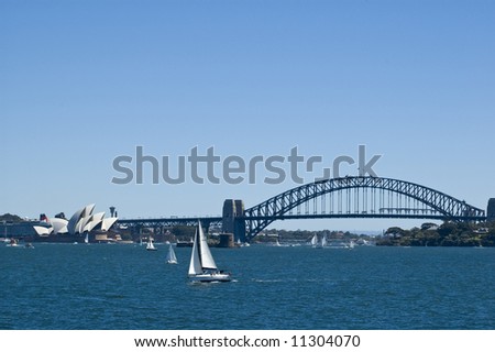 sydney opera house with queen victoria cruise ship  and harbor bridge in background and sailboat in foreground taken from harbor