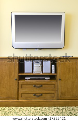 wall mounted flat screen television mounted above wooden cabinet with stereo