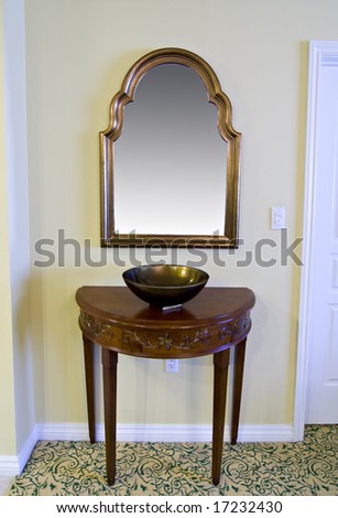 framed mirror and half circle table with decorative bowl