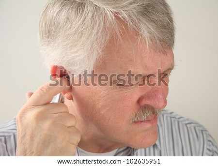 older man tries to relieve the pain deep in his ear