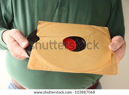 a man takes out an old record from an unmarked sleeve