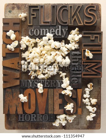 words associated with movie watching in old letterpress wood and metal type with popcorn