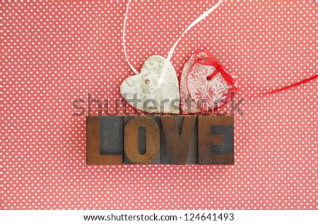 two salt dough ornaments with the word \'love\' in old wood type on a polka dot background