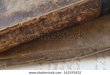 spine and covers of old, damaged books with a page of vintage script