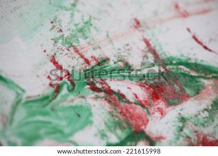 Red and green paint in an abstract design on a white background