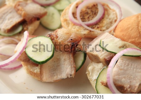 Pork belly, roasted and sliced on small buns with cucumber and onion slices
