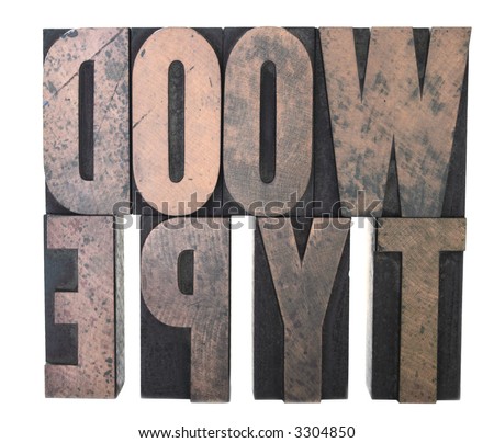 old and inkstained wood letters spelling out \'wood type\', isolated on white