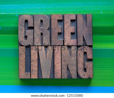 the words \'green living\' in letterpress wood type on a green and blue background
