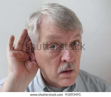 senior male cups his ear in order to hear better