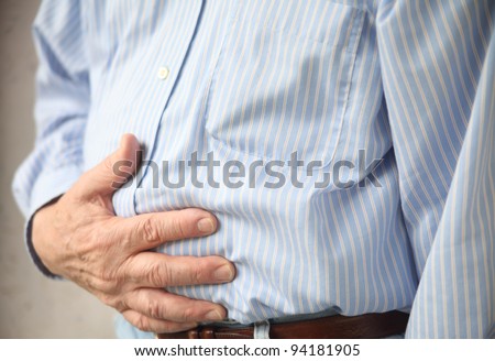 businessman with stomach pain, hands over abdomen