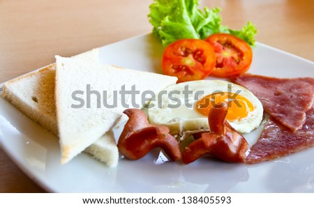 american breakfast with egg,ham,bread and sausage