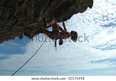 Adult climbing hard overhanging wall in Krabi, Thailand. Silhouette.