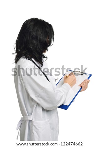 Young woman is standing and writing. She is wearing a white doctor\'s smock.