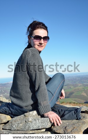 A woman is sitting on the top of mountain Larunn (La Rhune) in the Atlantic coast.